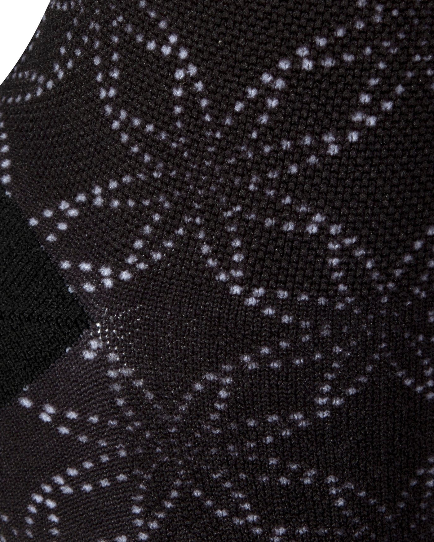 Textured heel view of black seamless toe sock with floral white dot print design and black heel.