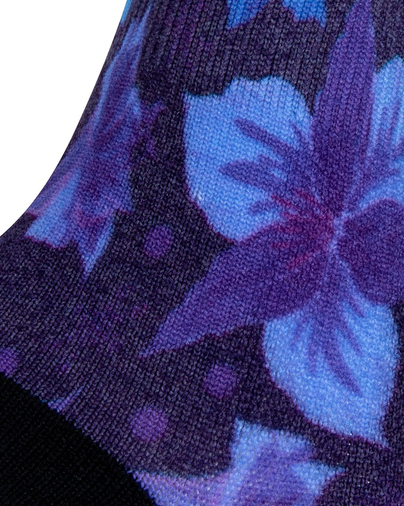 Textured heel view of blue seamless toe sock with blue and purple floral print design and black heel.