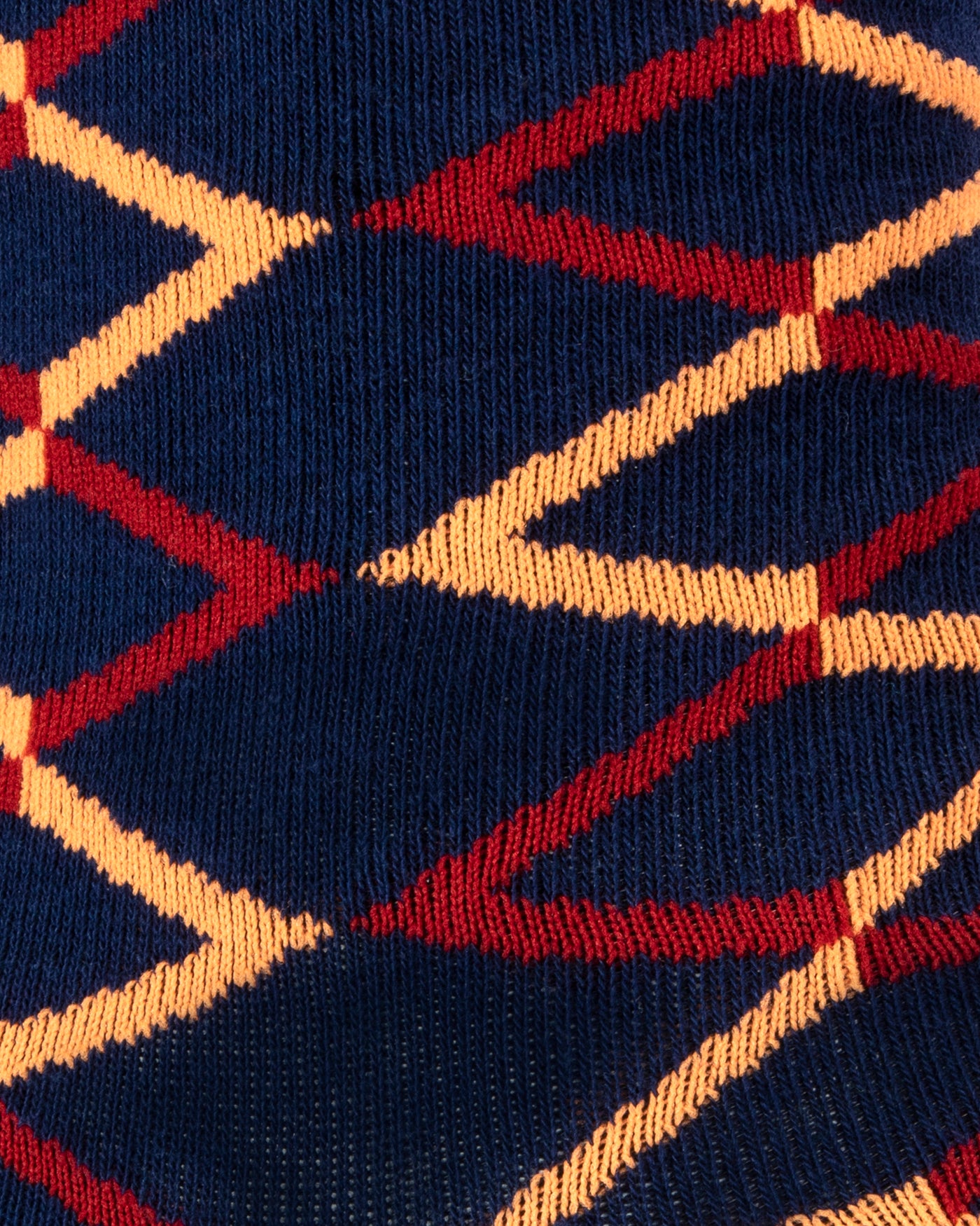 Textured view of a combed cotton dark navy seamless toe anklet with a red and orange diamond shape design.