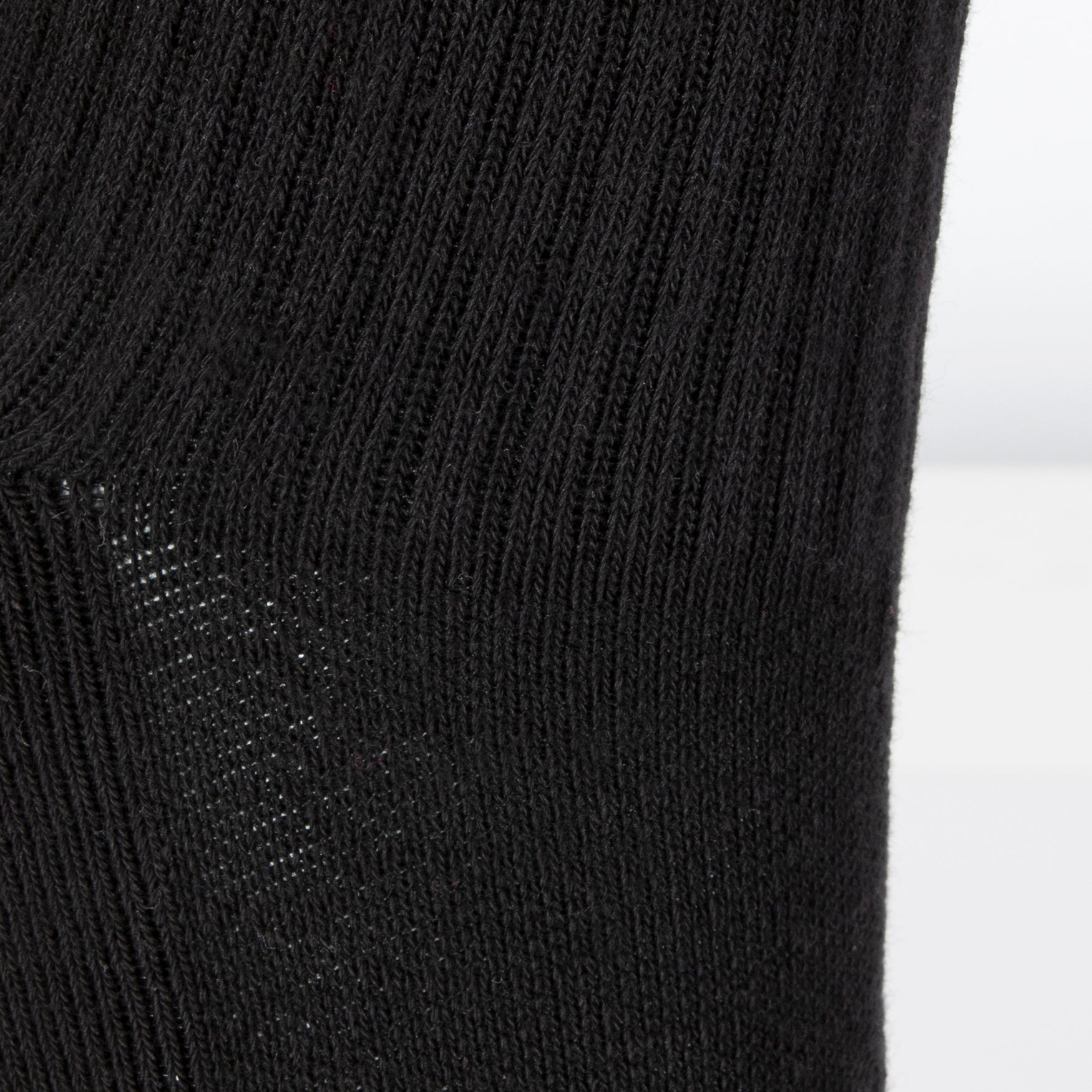 Textured view of a long length ribbed black combed cotton seamless toe anklet.