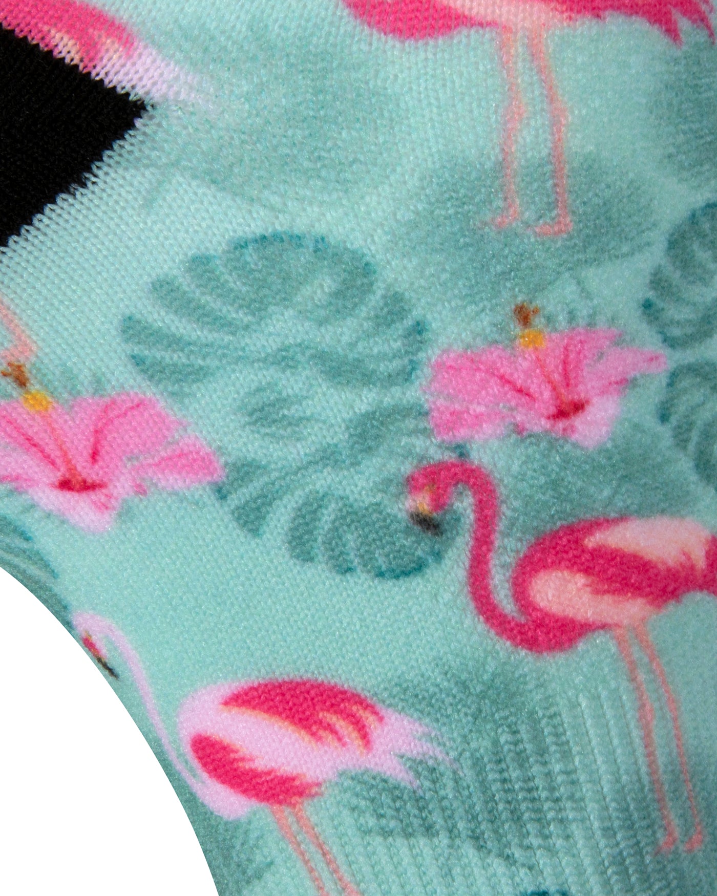 Textured heel view of a pastel mint green seamless toe sock with pink flamingo and green tropical leaves design print and black heel.