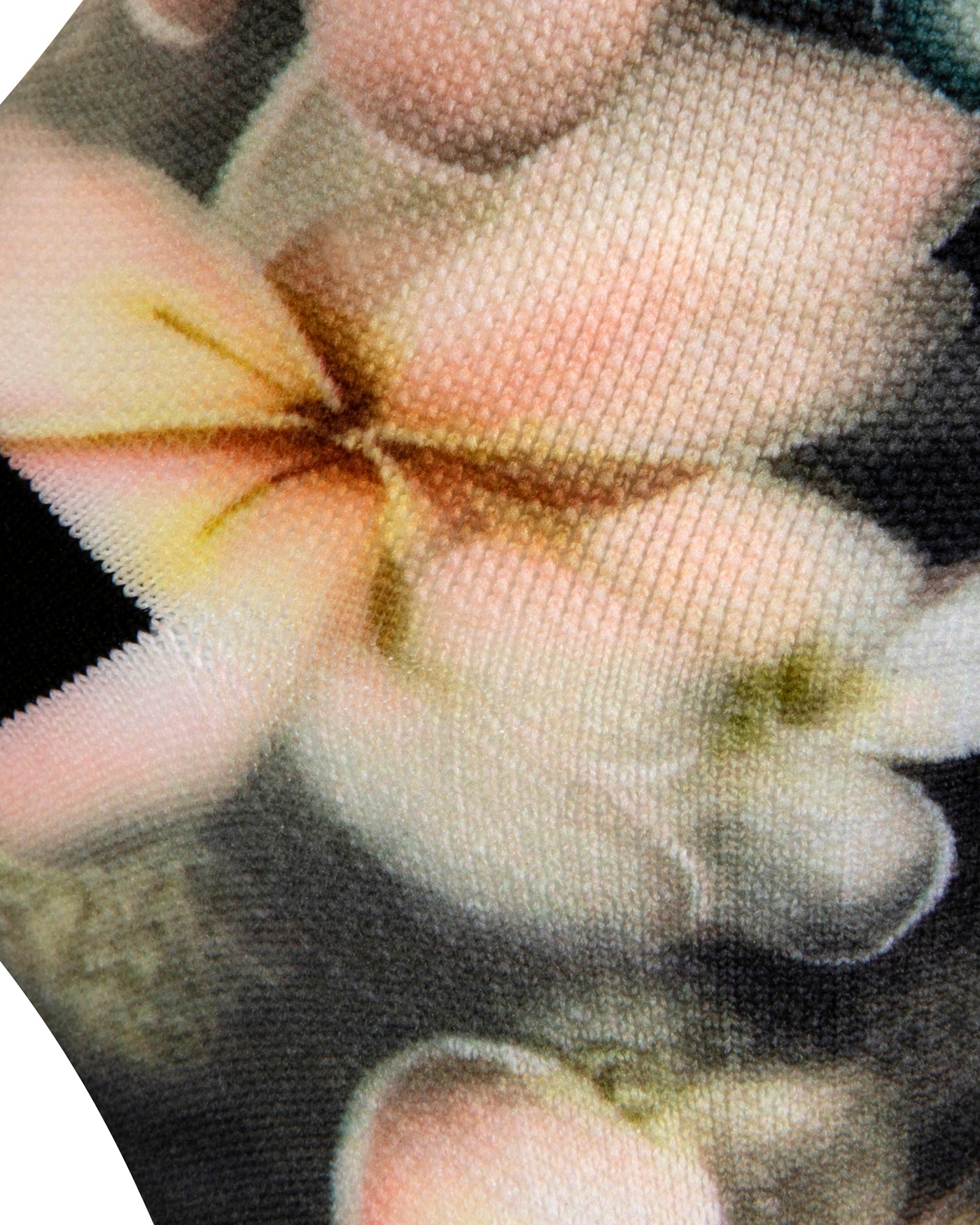 Textured heel view of a dark grey seamless toe sock with pastel hues of white, cream, yellow, and light pink frangipani print design and black heel.