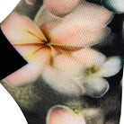Textured heel view of a dark grey seamless toe sock with pastel hues of white, cream, yellow, and light pink frangipani print design and black heel.