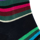 Textured view of a combed cotton black seamless toe anklet with green, blue, black, purple and pastel yellow stripes.