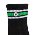 Side view of a long length ribbed black combed cotton seamless toe anklet with neon green and white stripes with Dapper Chameleon logo.