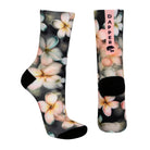 Dark grey seamless toe sock with pastel hues of white, cream, yellow, and light pink frangipani print design and black heel and toe.